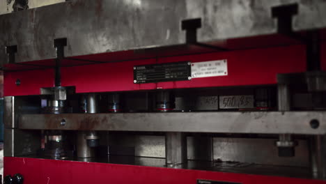 medium shot of a big automatic hydraulic press molding car parts in a factory