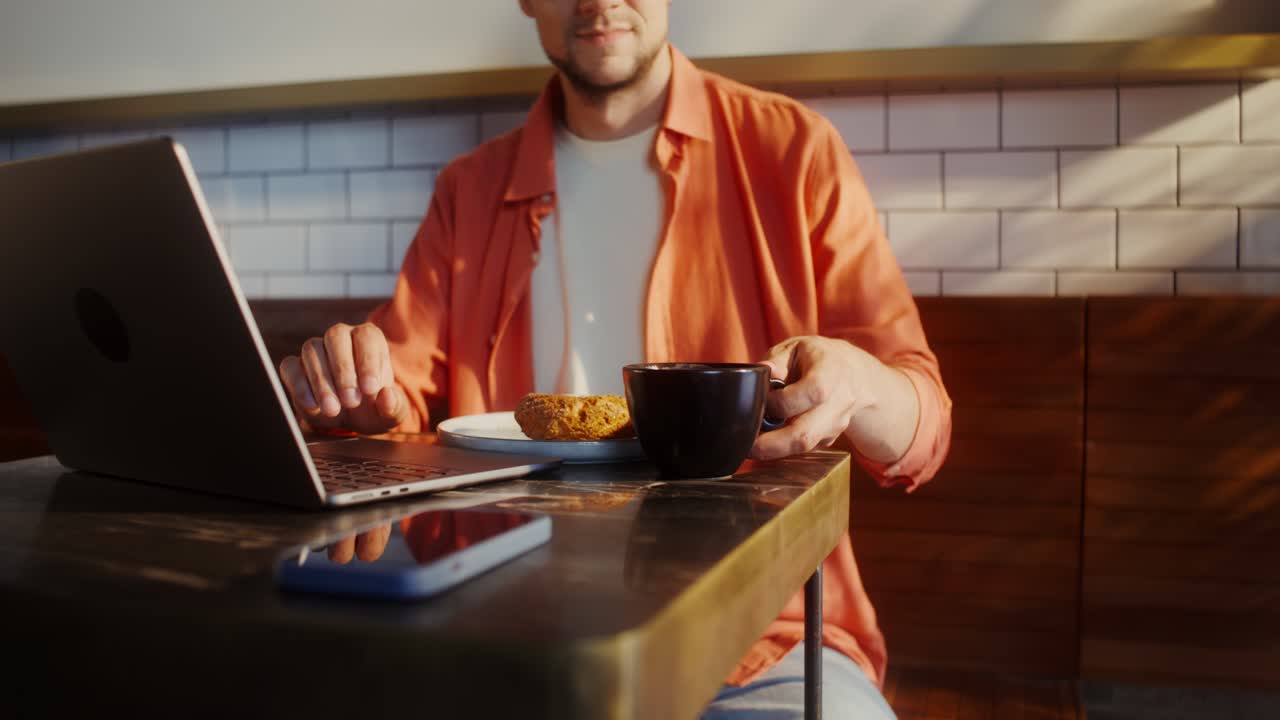 Uomo che lavora al portatile in un caffè