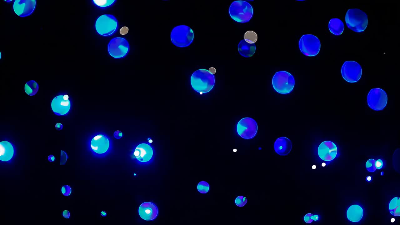Video abstrak lampu bokeh biru yang bersinar di latar belakang gelap, diambil dari sudut rendah