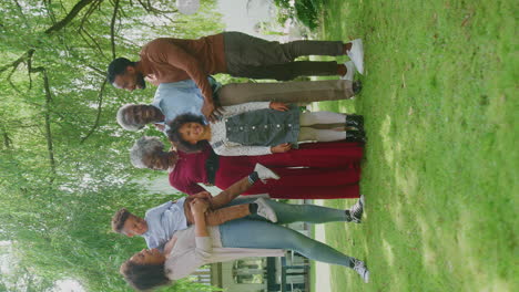 vertical video of smiling multi-generation family at home in garden together