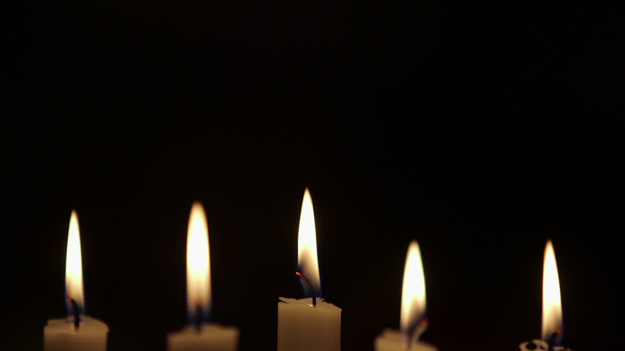 Cinque candele bianche accese al buio