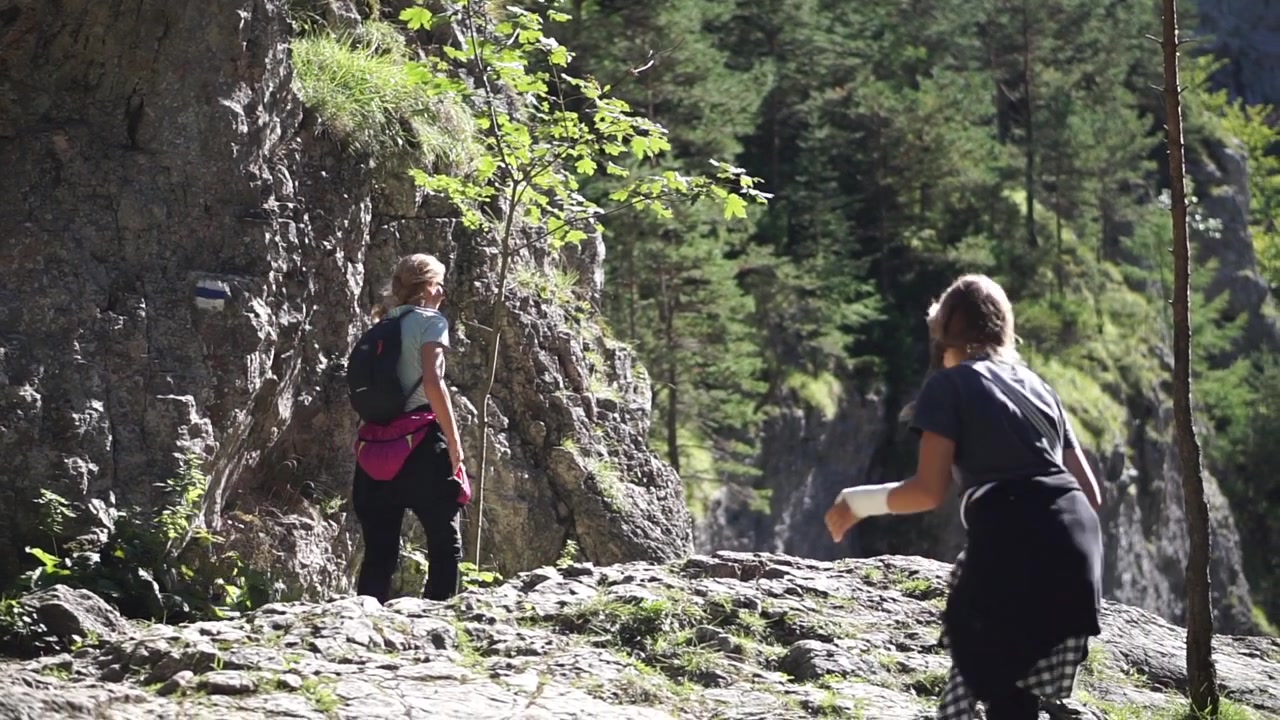 Due giovani donne che scalano una montagna rocciosa in una giornata di sole - Un'attività estiva faticosa ma divertente - Campo lungo