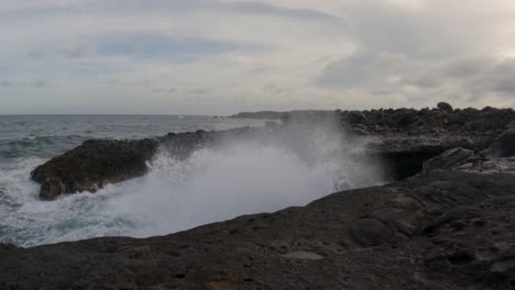 Las-Olas-Del-Mar-Rompiendo-En-Las-Rocas-A-Lo-Largo-De-La-Orilla-Del-Mar-Lanzando-Spray-En-El-Aire