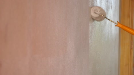 painting a wall with a paint roller
