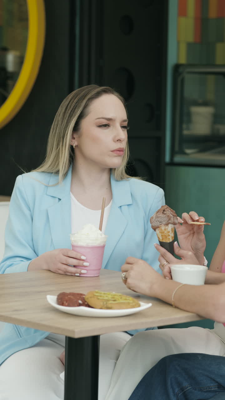Wide shot of a group of friends chatting animatedly at an ice cream shop. A relaxed, youthful, and authentic scene that conveys friendship, connection, and enjoyment.