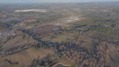 Aerial-footage-capturing-the-rustic-beauty-of-rural-Lincoln,-Alabama,-with-scenic-views-of-lakes,-trees,-houses,-and-expansive-skies