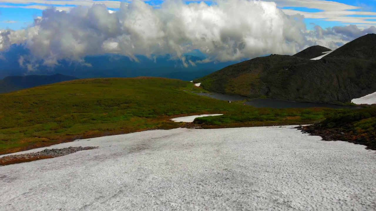 Vuelo de dron sobre el Parque Nacional Daisetsuzan, glaciar que desemboca en un lago en las montañas