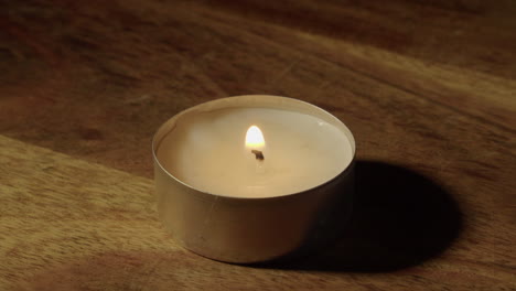 narrow focus closeup: one tea candle lit with flaming propane torch