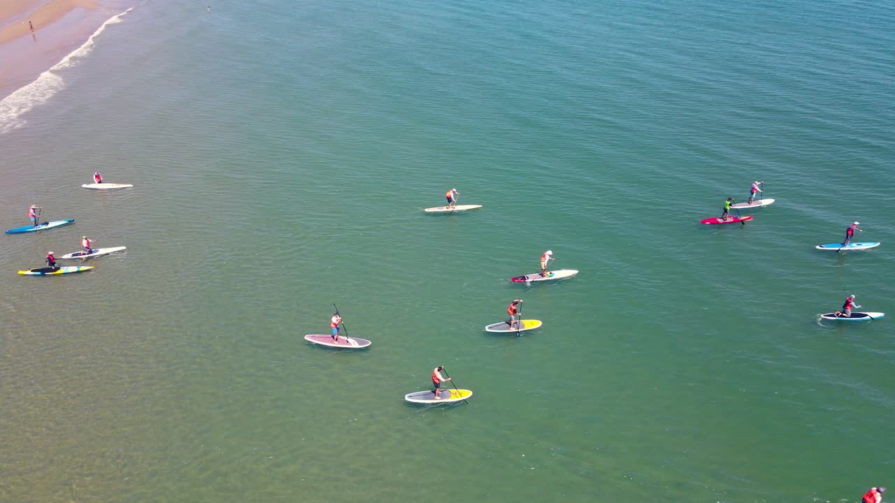standup paddleboarders en evento de carreras en aguas de la playa de rexhame, marshfield