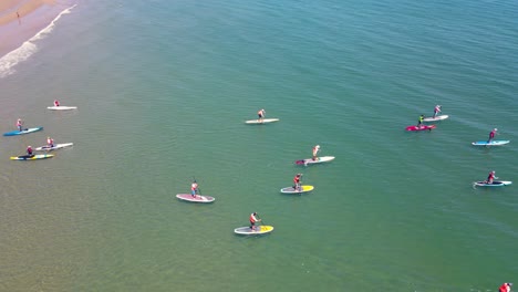 standup paddleboarders at racing event on waters of rexhame beach, marshfield