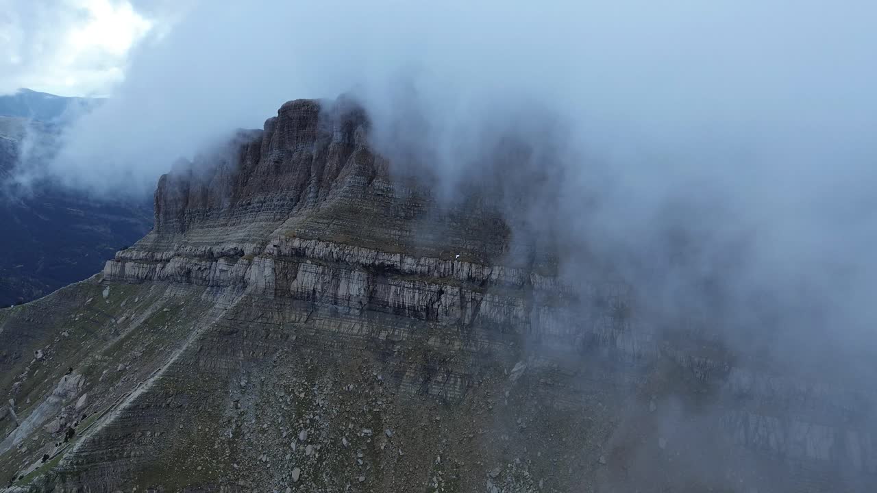 Misty aerial view of Pico Tortiellas mountain in Aragón Spain surrounded by drifting clouds