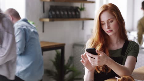 woman using phone and drinking coffee in a cafe