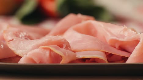 ham italian mordatella, man slices of traditional italian antipasti mortadella sausage on a wooden cutting board, close up macro of chicken or turkey jamon, fat breakfast dish.