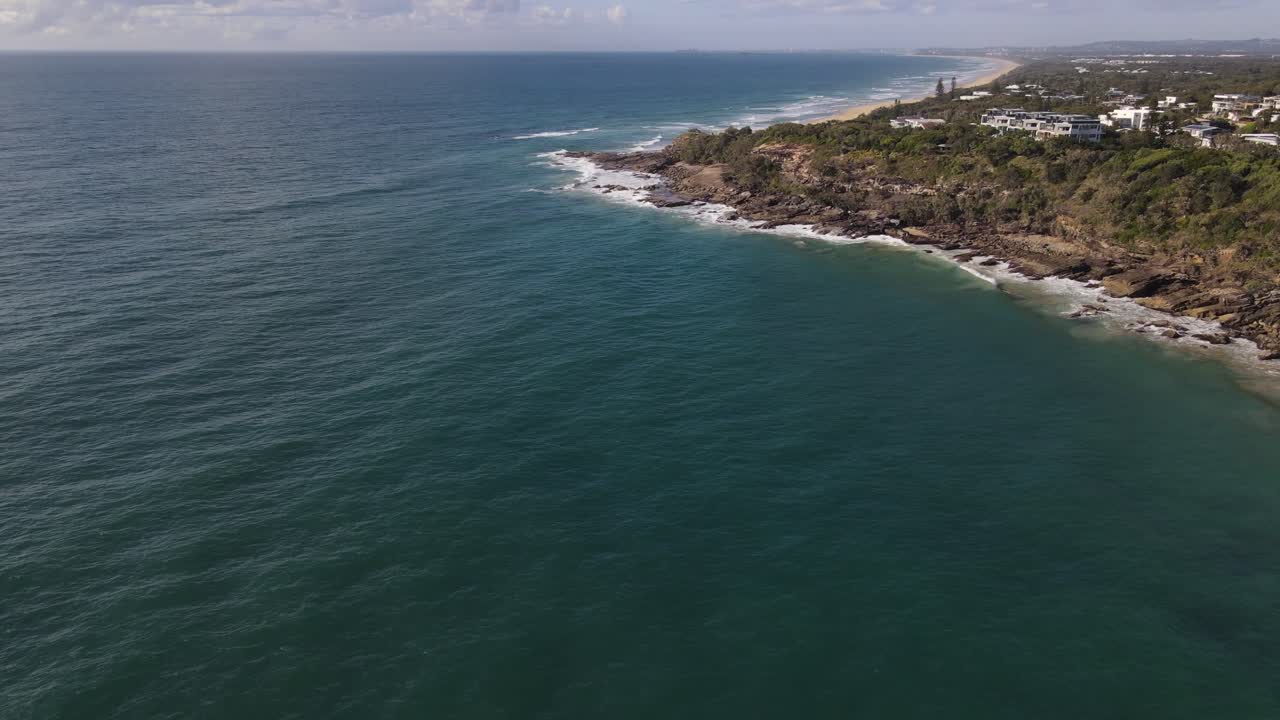 Drone aerial over Coolum Beach with waves going into the coastline