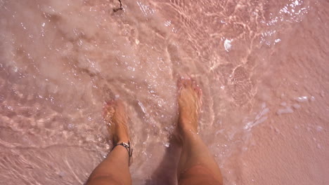person on pink sandy beach on komodo island in bali, indonesia. - pov