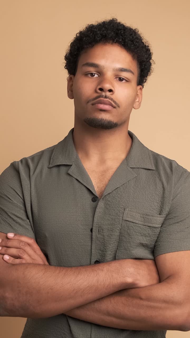 Confident man looking at camera in beige studio