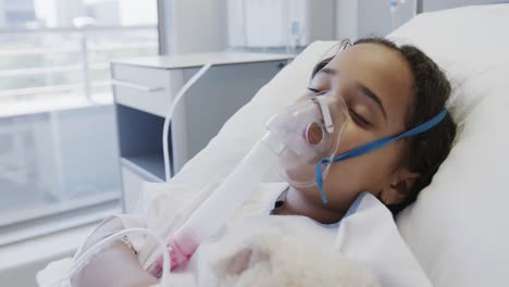 Biracial-sick-girl-patient-with-oxygen-mask-sleeping-in-hospital-bed-in-slow-motion