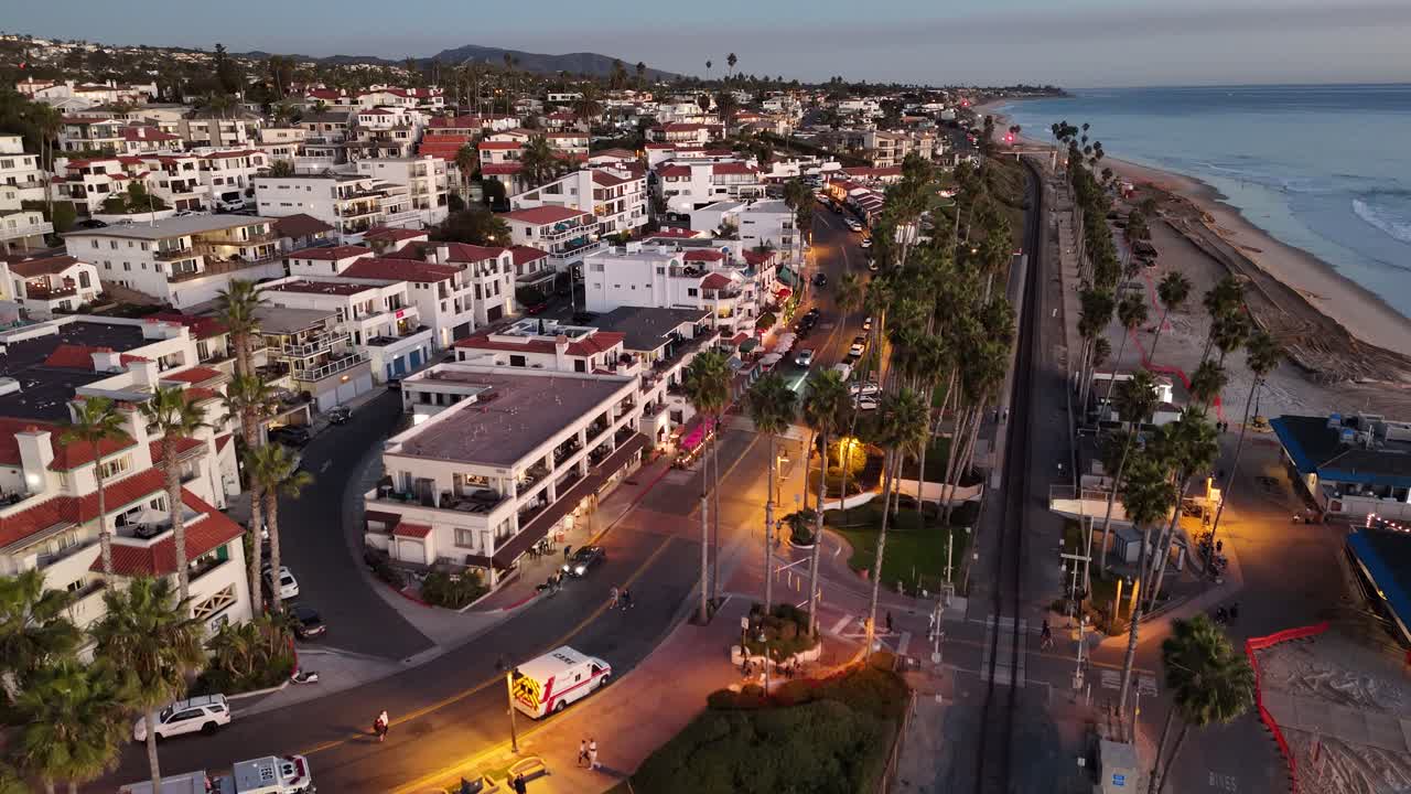 A drone-captured aerial view of San Clemente’s Pier Bowl and coastline during twilight, showcasing the Spanish-style architecture, palm-lined streets, and beach access along the Pacific Ocean