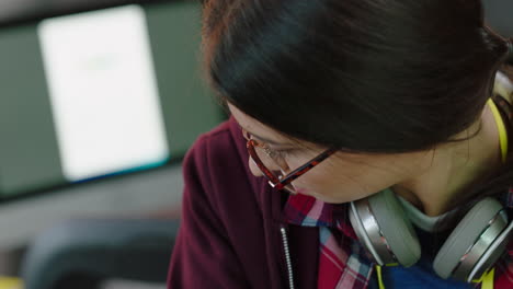 close-up-portrait-young-caucasian-woman-student-using-laptop-computer-browsing-online--reading-digital-email-on-screen-bored-looking-intern-wearing-glasses-in-office