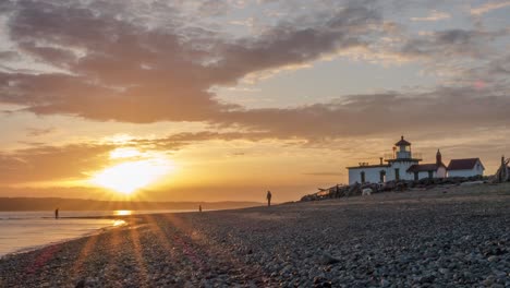 La-Puesta-De-Sol-Más-Allá-De-Las-Montañas-En-La-Playa-De-Un-Faro