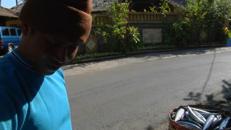 A-Man-Displays-Baskets-Of-Fresh-Fish-On-The-Side-Of-A-Road