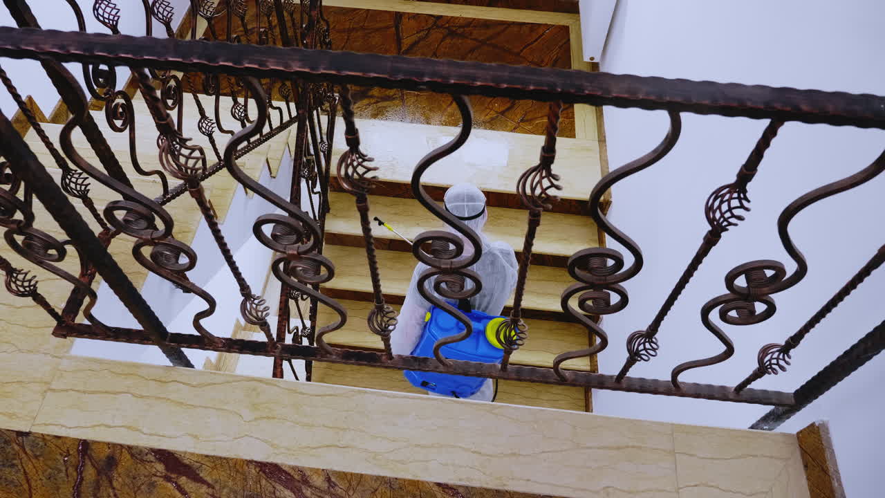 안전복을 입은 남자가 살균제를 스프레이합니다.