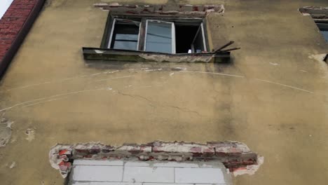 movimiento de dolly de bajo ángulo disparado en ventanas rotas de un edificio abandonado en ruinas