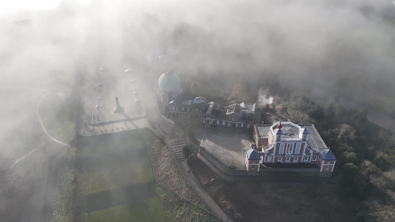 Breathtaking aerial pan of the Royal Observatory, Greenwich, shrouded in mystical mist. Stunning 4K footage captures London’s iconic landmark, showcasing its beauty in a dreamy, atmospheric glow.