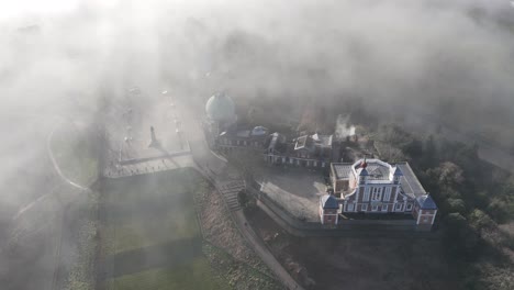 breathtaking aerial pan of the royal observatory, greenwich, shrouded in mystical mist. stunning 4k footage captures london’s iconic landmark, showcasing its beauty in a dreamy, atmospheric glow.