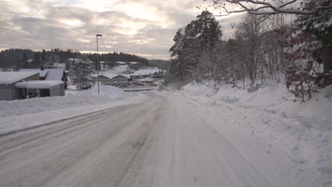 Dron-Volando-Bajo-En-Un-Camino-Rural-Cubierto-De-Nieve-Al-Atardecer