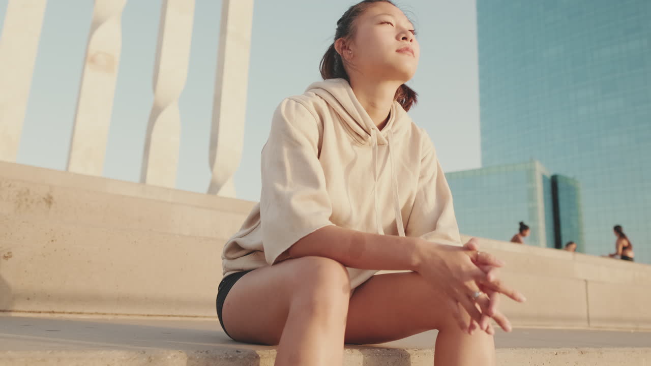 Woman sitting outdoors in urban setting