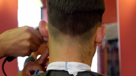 hombre recibiendo su cabello recortado con trimmer 4k