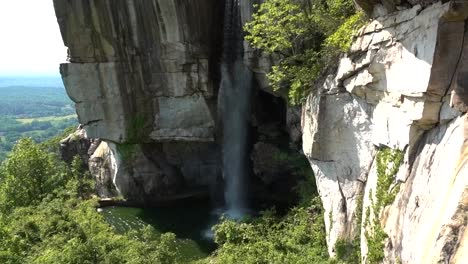 a beautiful waterfall flowing down the cliff side into a pond