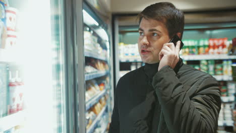 hombre hablando por teléfono en la tienda de alimentos