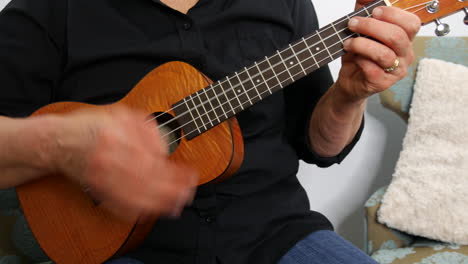 vista desde abajo de una mujer tocando un ukelele, alejada, de mano