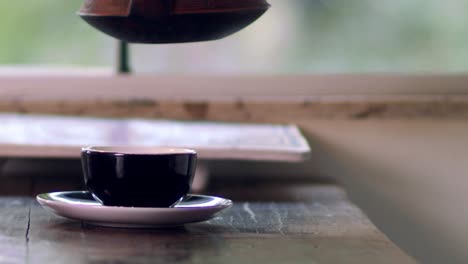 Woman's-hand-seen-pouring-hot-water-infused-with-organic-herbal-tea-from-a-vintage-Asian-teapot---isolated-slow-motion