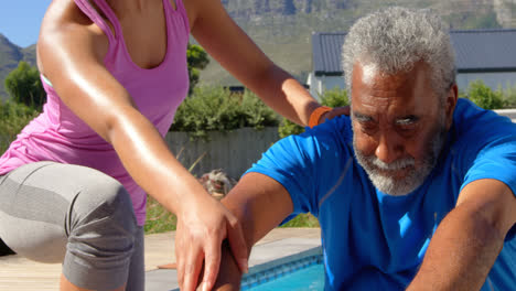 Front-view-of-mixed-race-personal-trainer-exercising-with-determined-senior-black-man-in-backyard-4k