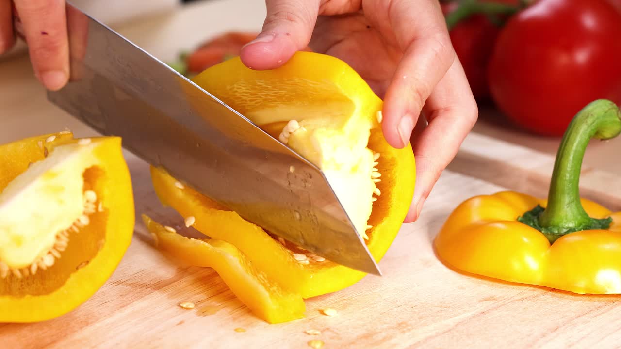 배경 에 토마토 가 있는 고추 를 잘라내는 손