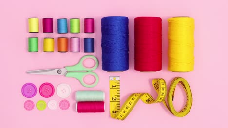 sewing and knitting items layout move on pastel pink background. stop motion flat lay