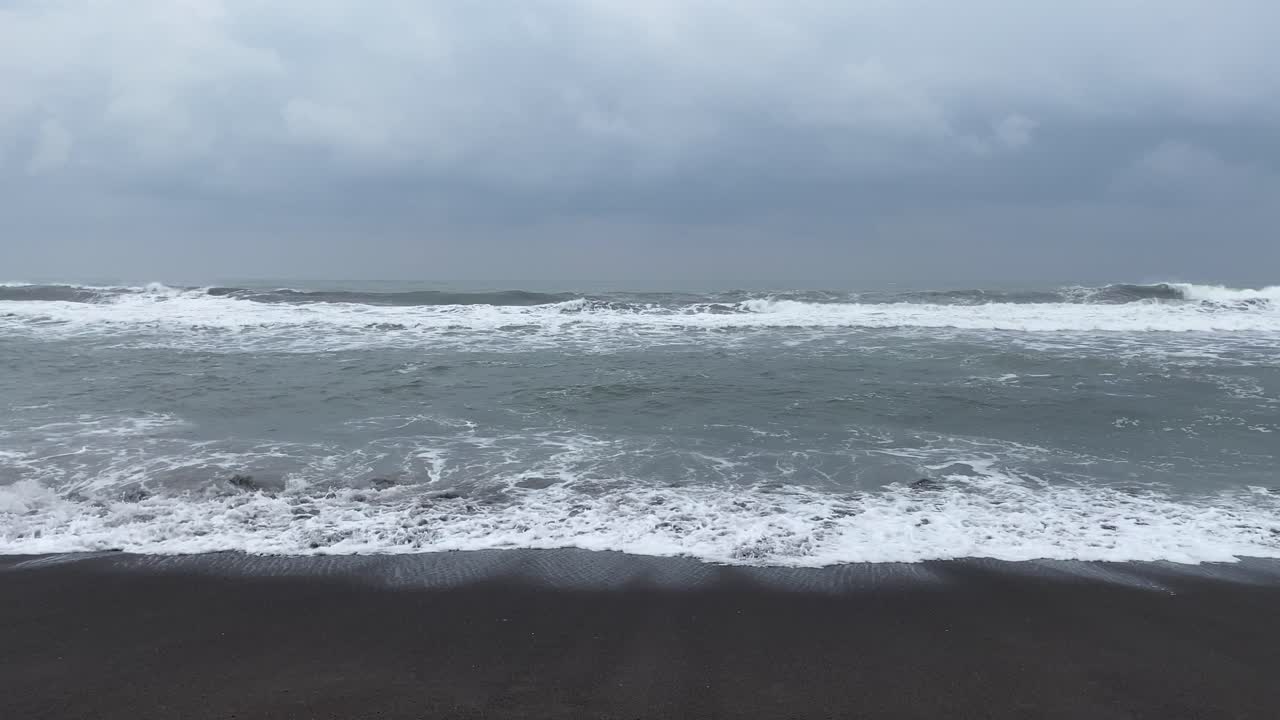 인도네시아 섬의 검은 모래 해변에서 폭풍우가 치는 바다 - 정적