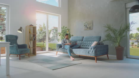 man sitting on sofa with a laptop