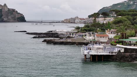 white beach house, island ischia in italy, castle aragonese in background