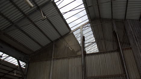 view of a rustic metal frame barrier of a roof inside a warehouse structure