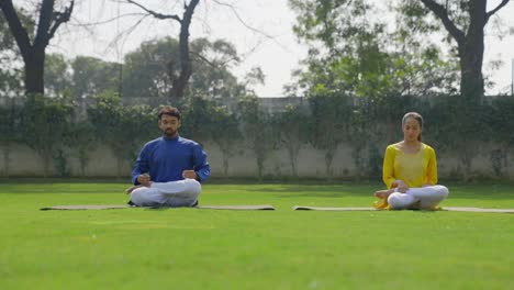 indian couple doing lotus yoga pose