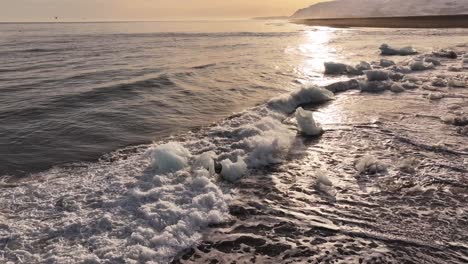 icy waves hitting black sand at sunset, diamond beach, iceland