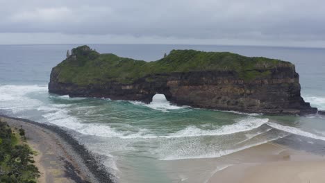 Waves-coming-through-Hole-in-the-Wall-in-Indian-Ocean-with-rocky-green-cliffs