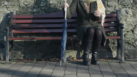 Woman-sitting-on-city-bench-then-stands-up-and-walks-away