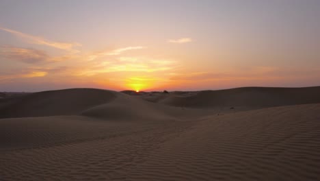 Increíble-Sol-Naranja-Se-Pone-Sobre-El-Horizonte-De-Las-Majestuosas-Dunas-De-Arena-Del-Desierto,-Estableciendo-Tiro