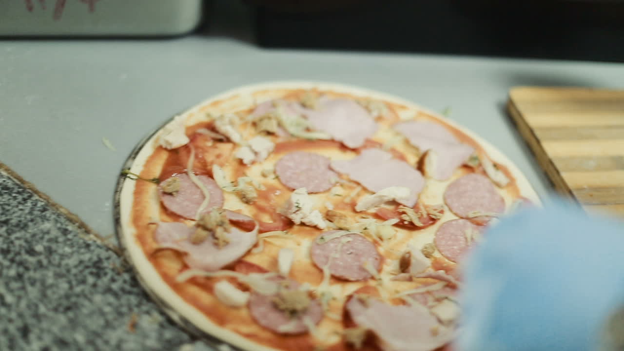 Step To Making Pizza By Chef. Chef giving finishing touch to pizza in kitchen