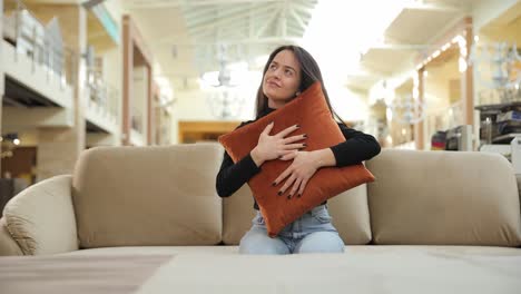 young woman hugging soft pillow on stylish sofa in furniture store young woman enjoying a cozy peaceful moment hugging a soft pillow on a stylish sofa in a furniture store